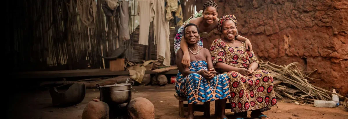 Grandmother Angel, 80, her daughter Pierrette, 42, and granddaughter Blanche, 18, sitting in a group smiling at the camera.