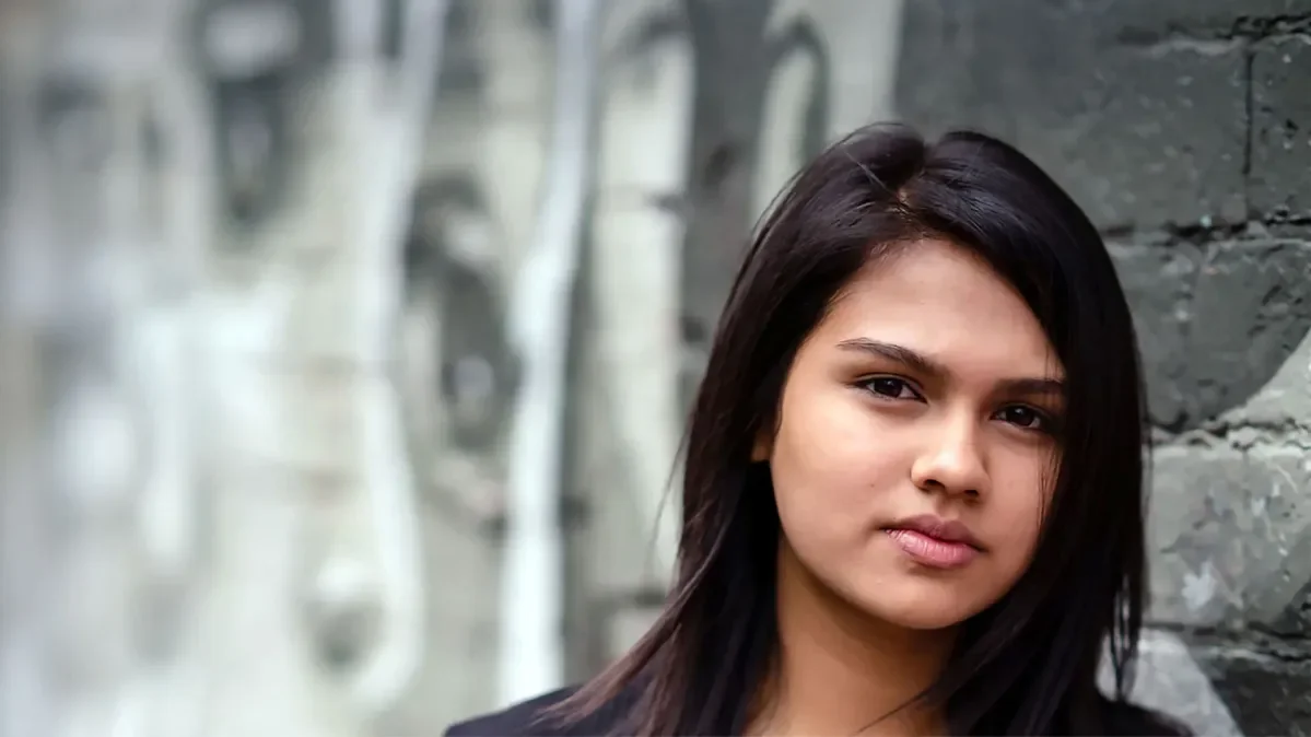 Raisa, 17, from Birmingham standing in front of a wall of graffiti