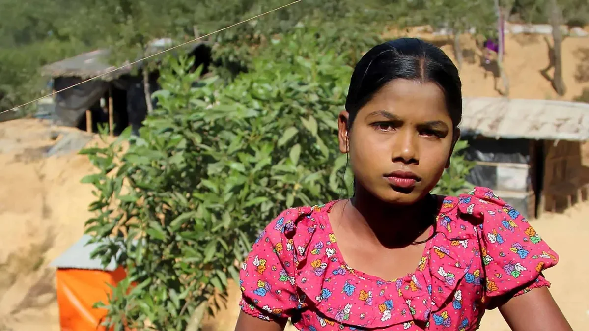 A girl standing outside in her village.