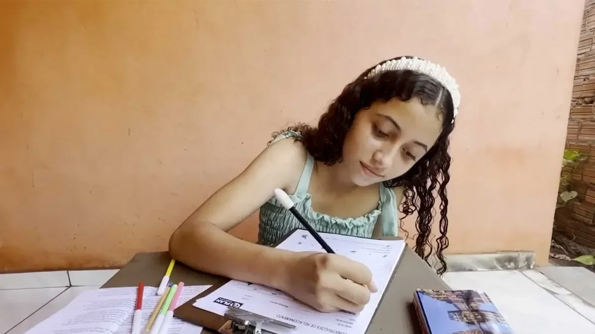 Kaila writing a letter to her sponsor. 