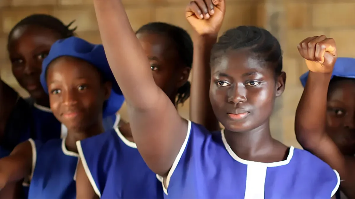 Girls wearing blue with raised fists