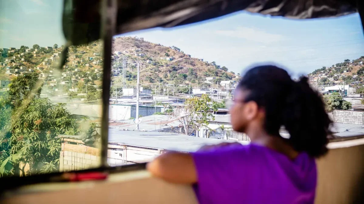 A girl in Ecudaor looking out over a town from a balcony