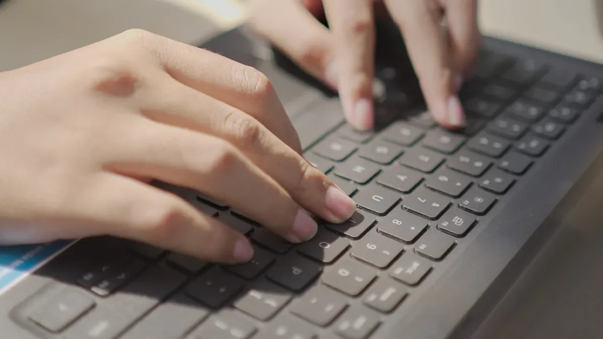 Close up of hands typing on keyboard