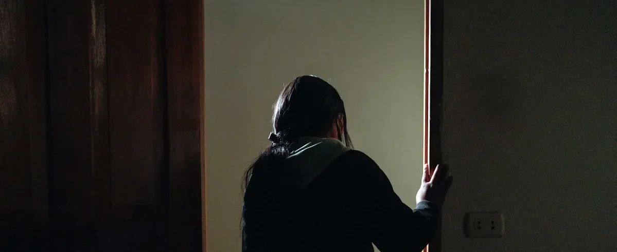 Flor* 20, who was forced into an abusive union stand in a doorway in her house in Peru.
