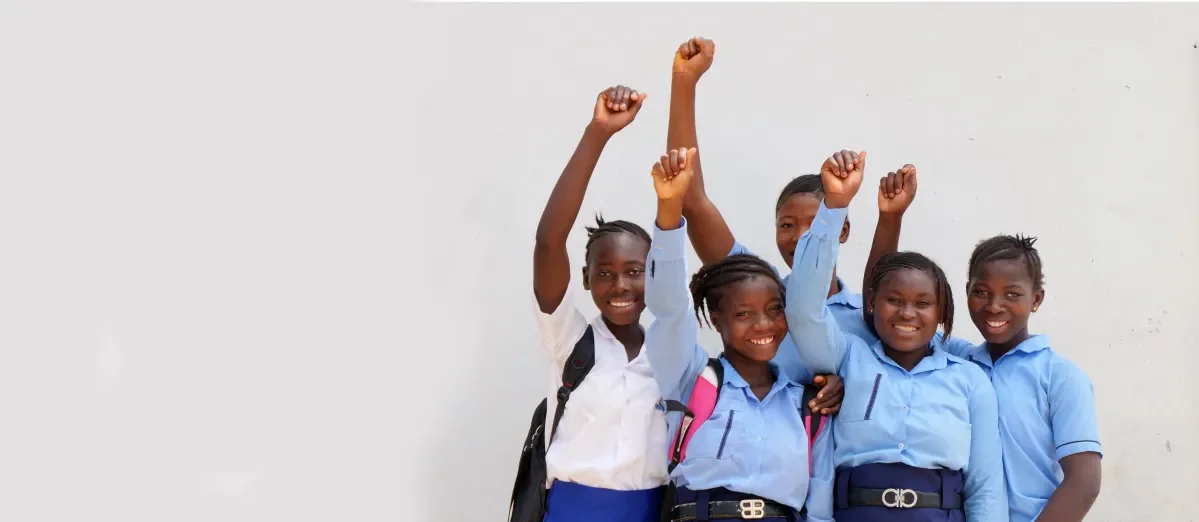 Girls stand with their fists in the air. 