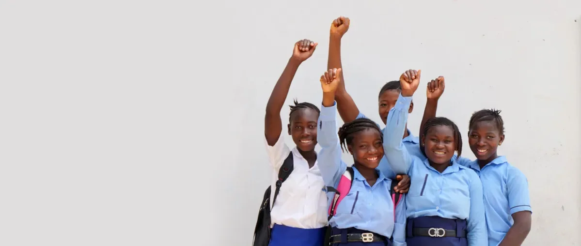 Girls stand with their fists in the air. 