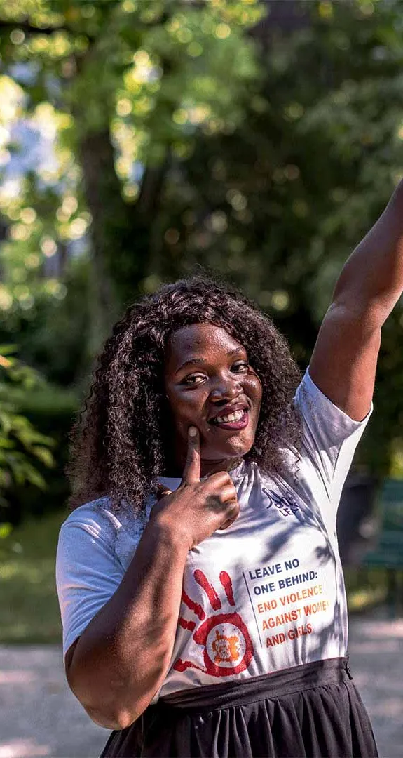 Racheal, 26, pointing her finger to the sky and smiling at the camera