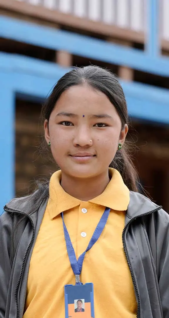 Lakshina standing in front of school looking at camera