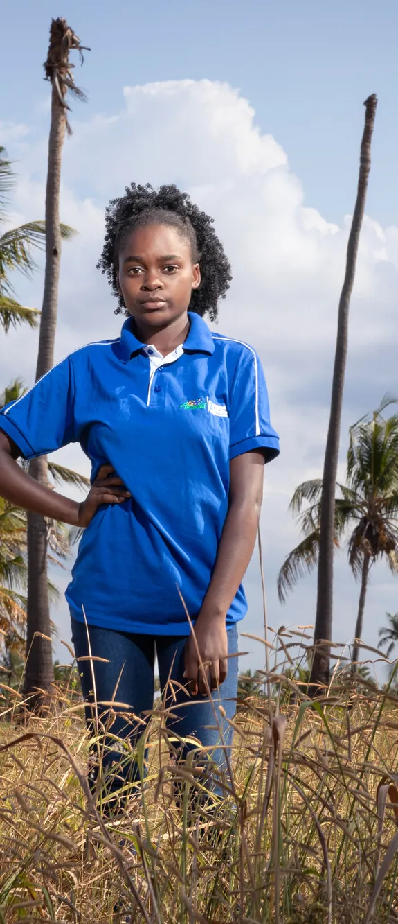 Eunice, 18, stands in a field in Mozambique. She is passionate about defending the rights of girls