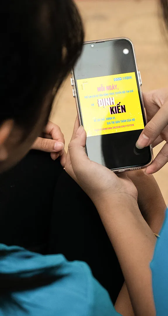 Two girls looking at a petition on a phone.