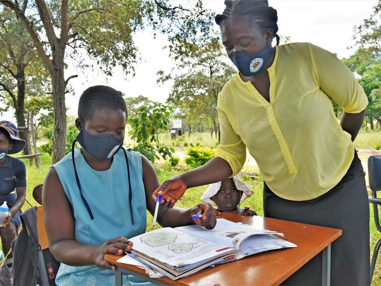 Susan, 19, learning with her teacher in an outdoor classroom in Zimbabwe