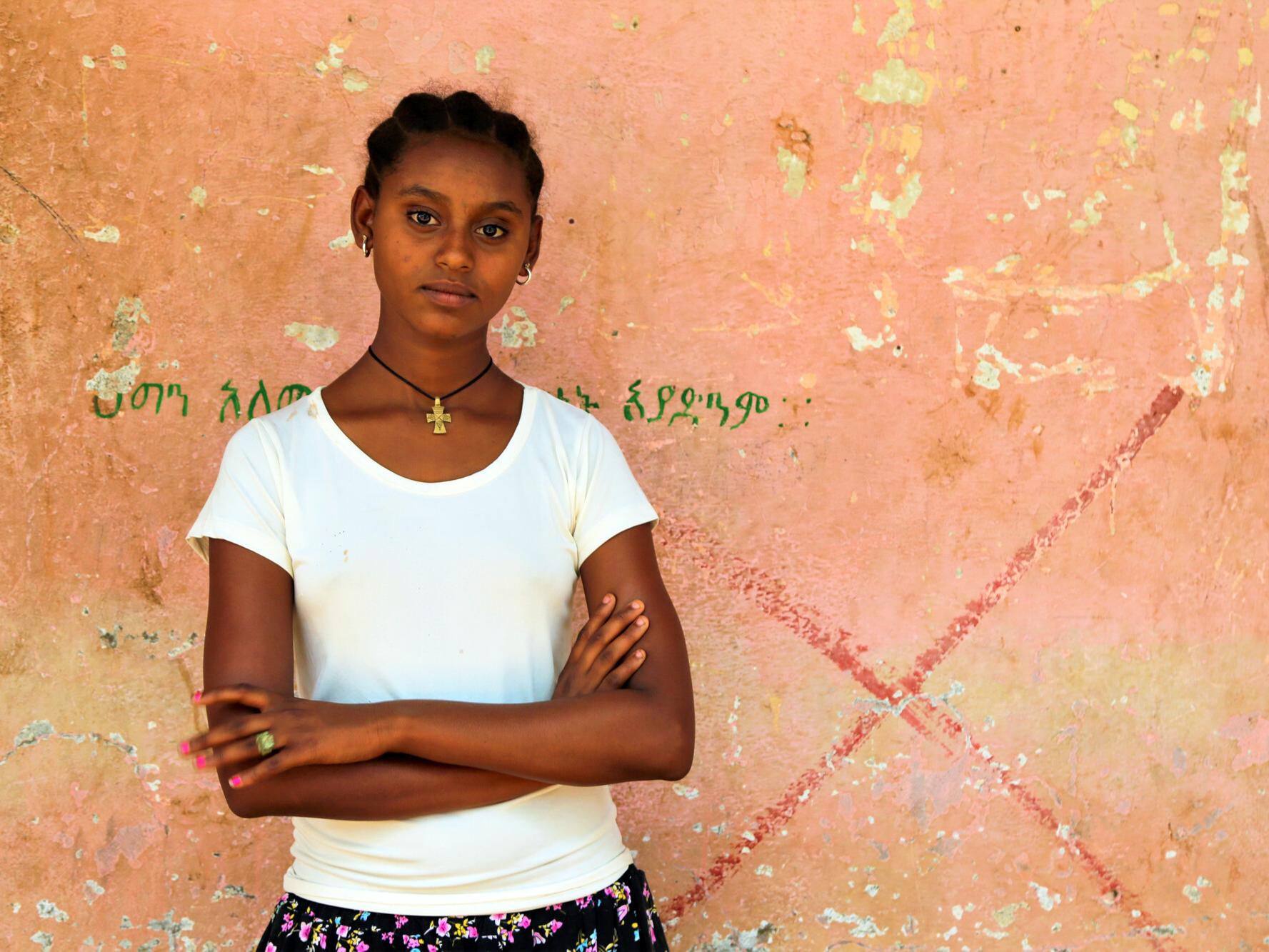 Worke, 14, standing in from a wall in the camp where she lives in Ethiopia. 