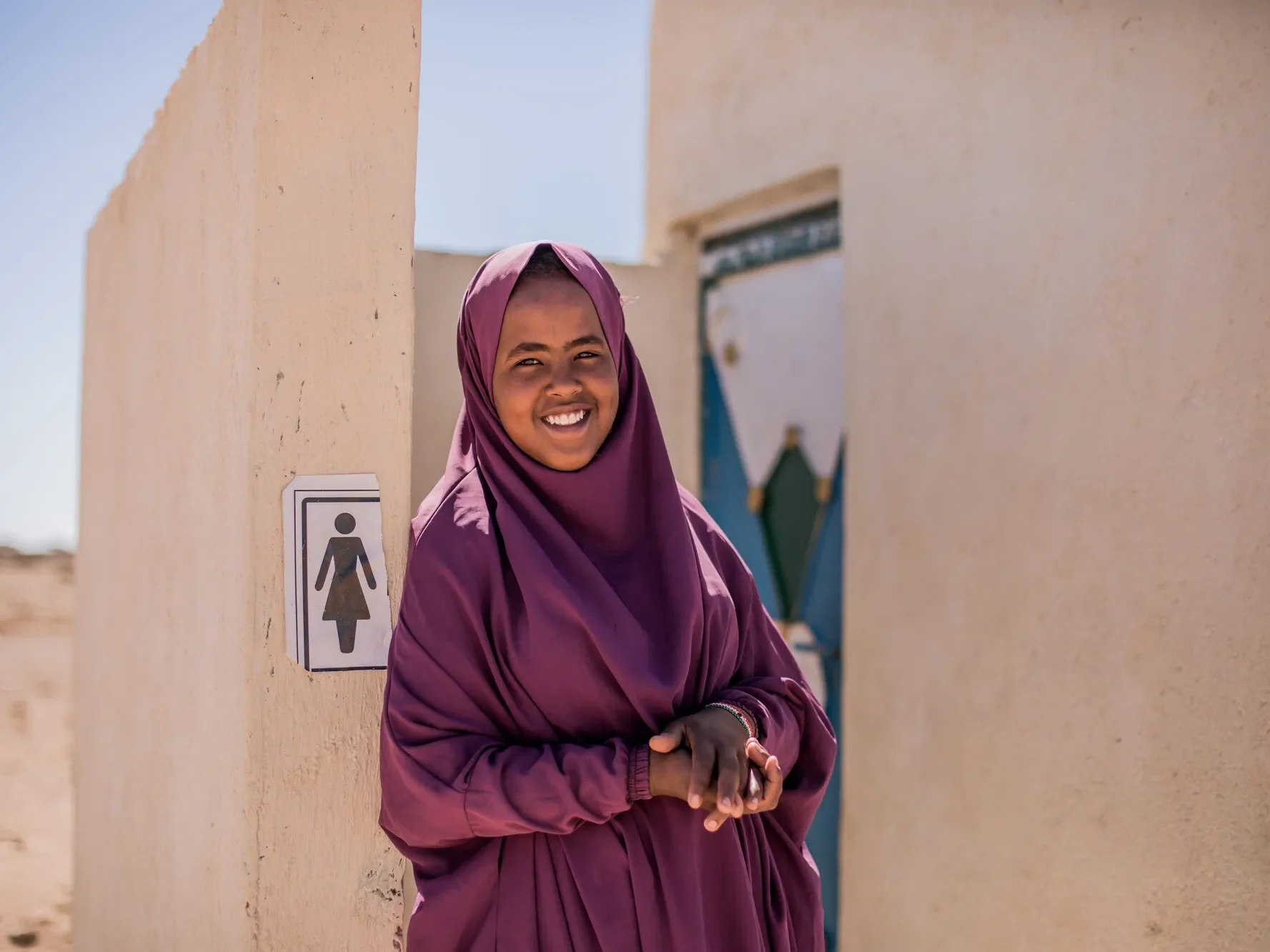 Hamda, 15, standing outside the new toilet facilities built by Plan International in Somalia