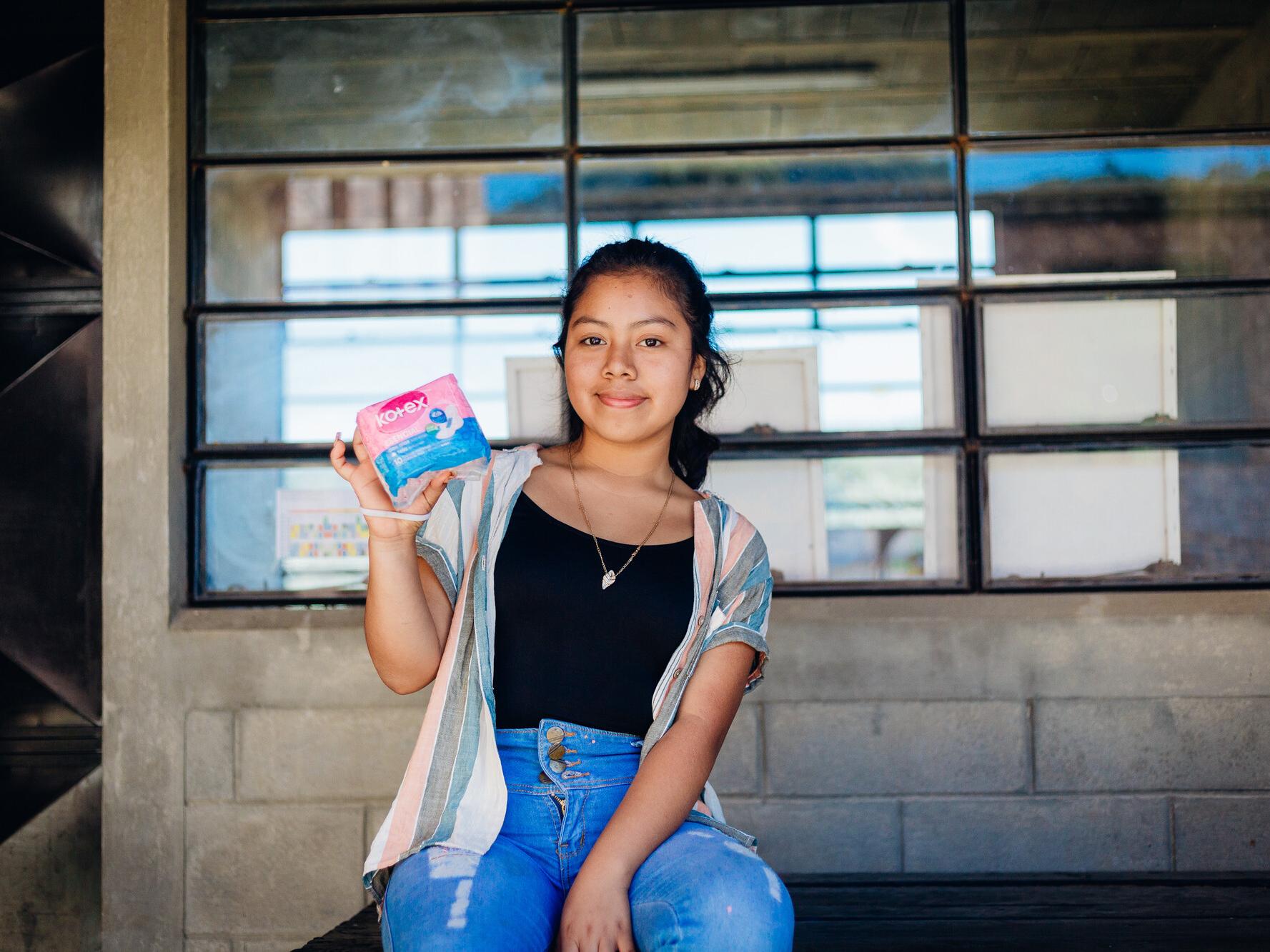 Dalila, 15, holding a dignity kit distributed by Plan International