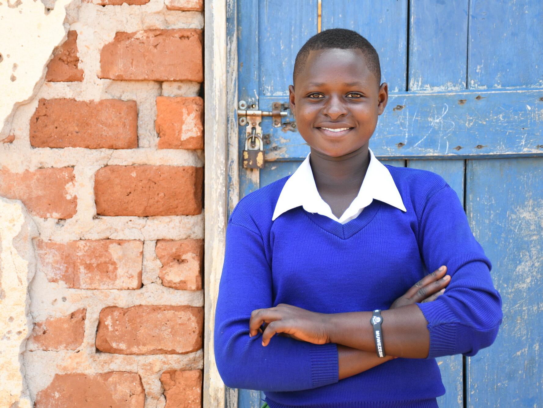 Hellen, 14, standing outside her school in Tanzania