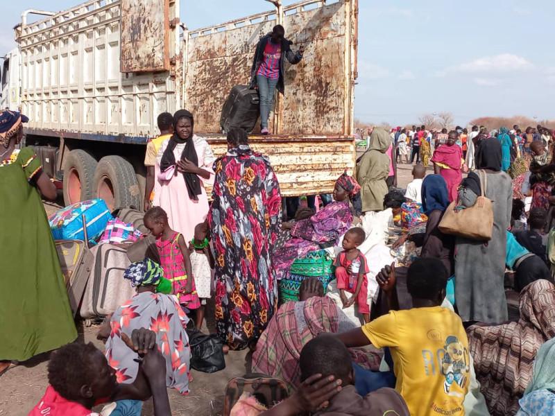 Families in Sudan are using buses and trucks to flee the violence in their country. Credit: Plan International