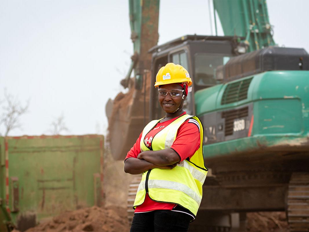 Ikilimah standing in construction site smiling at camera