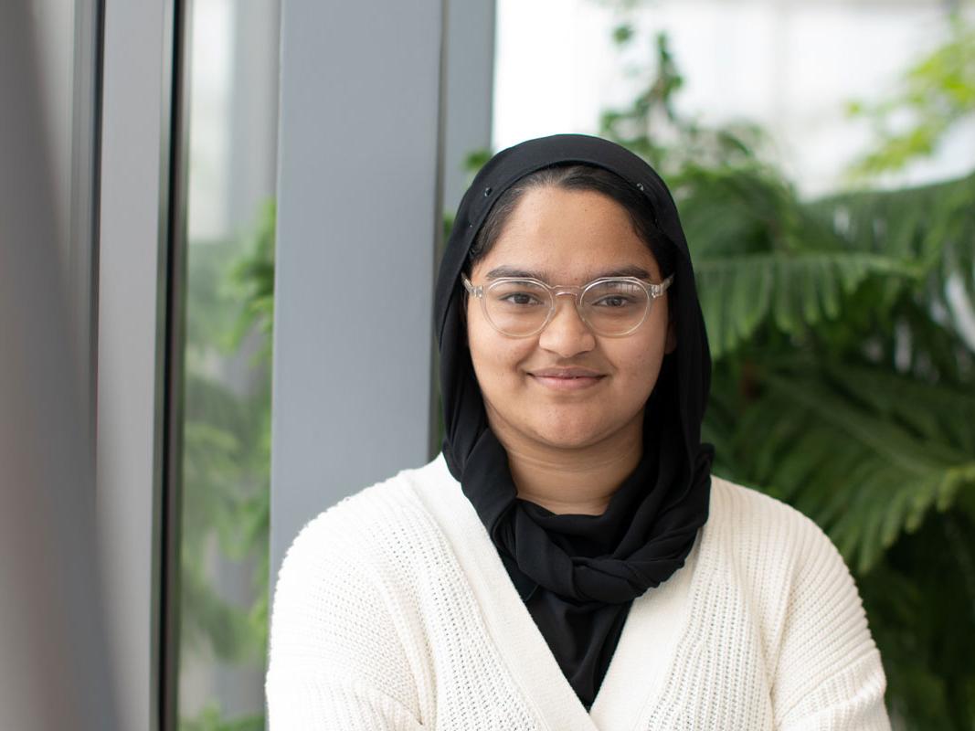 Head and shoulders shot of Qahira smiling with plants in background