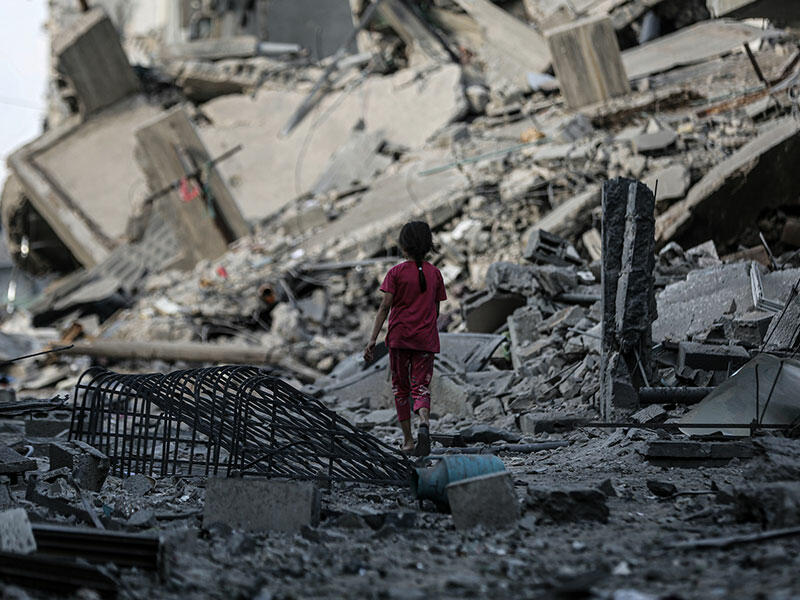 A girl walks among ruins in Gaza after Israeli bombardments in October 2023 (Ali Jadallah/Anadolu via Getty Images) 