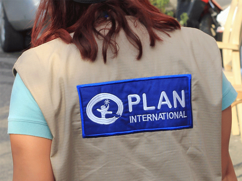 Back of Plan International response team member's jacket with Plan International logo on it