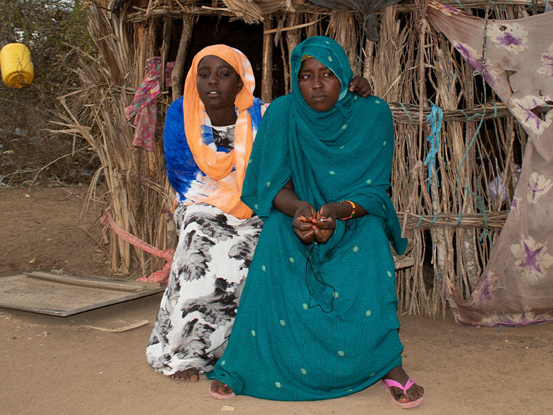 Najma, 12, and her mother Lulu sitting outside their home in Kenya.