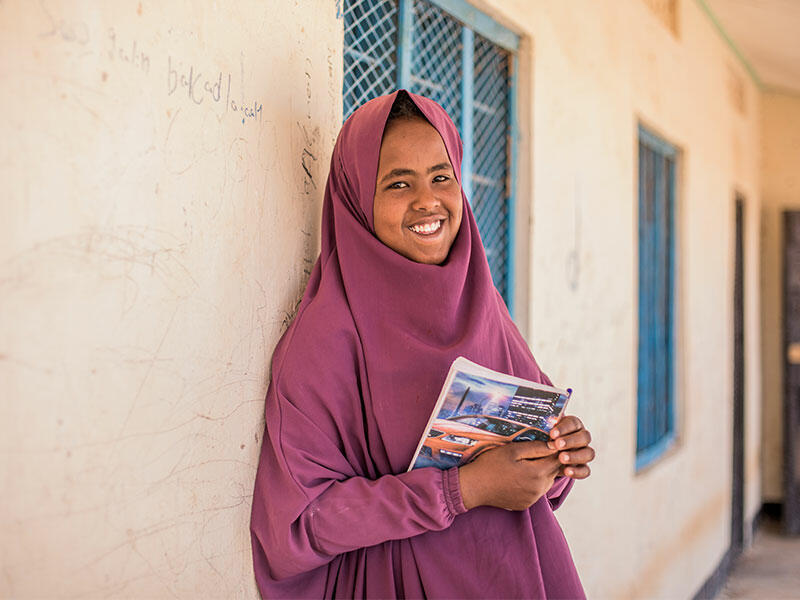 Hamda standing with books in her hand