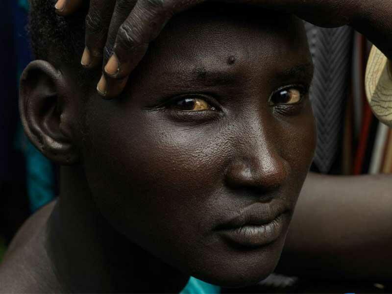 Close up of young woman's face looking into camera who is waiting for food distribution