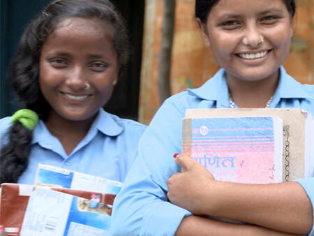 Two girls holding their school books