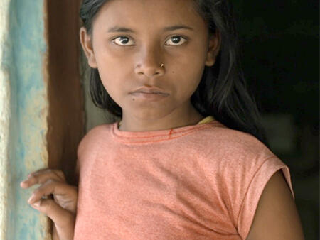 A young girl looking straight at the camera