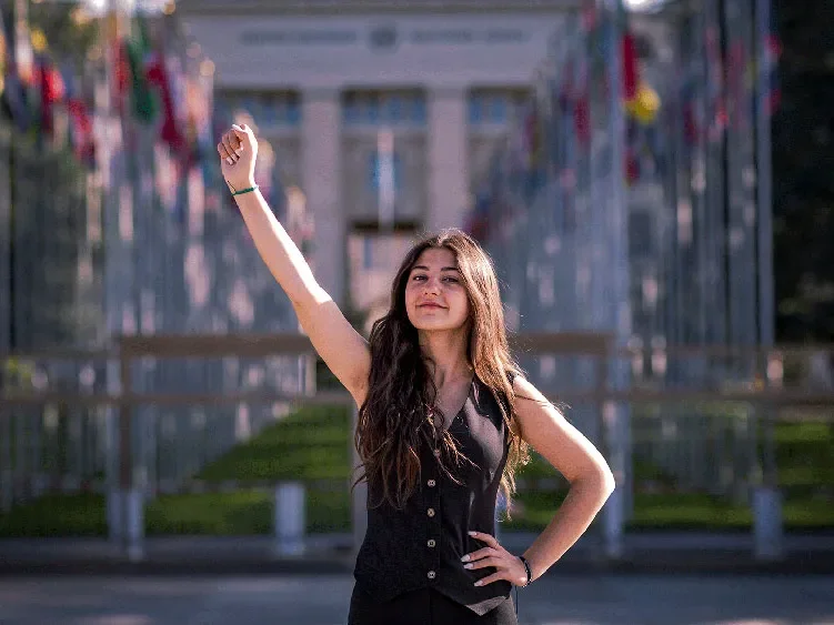 Lynne, 18, raising a clenched fist in solidarity whilst looking at the camera