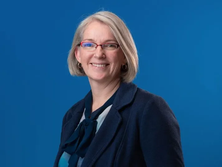 A member of the board of trustees smiles at the camera