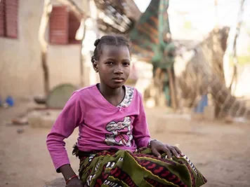 Moussou, 10, sits outside her school in Mali
