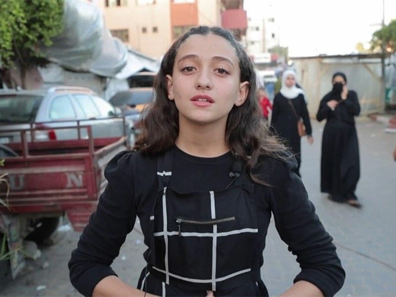 Girl standing on street in Gaza looking at camera