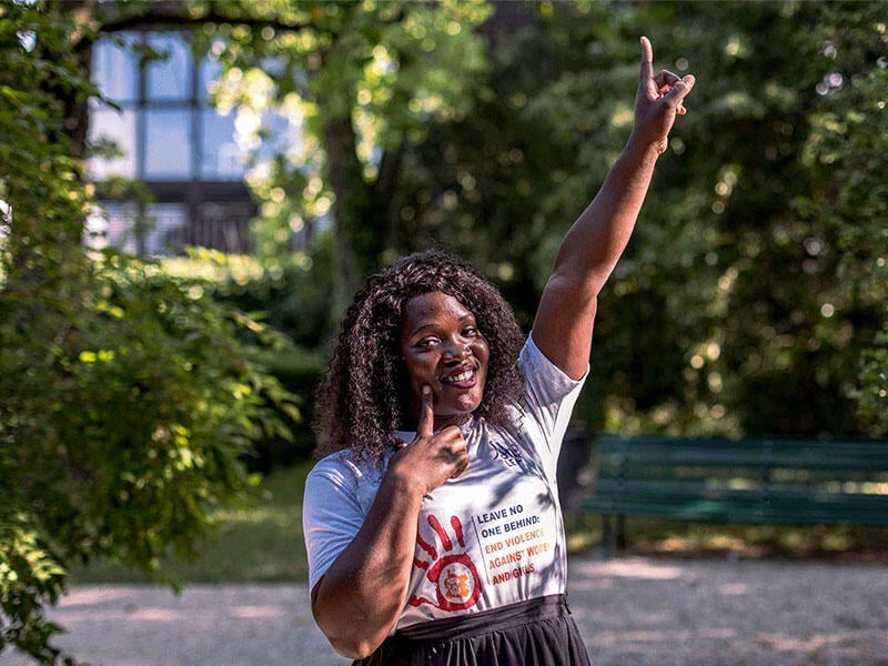 A girl points her arm in the air and poses for the camera