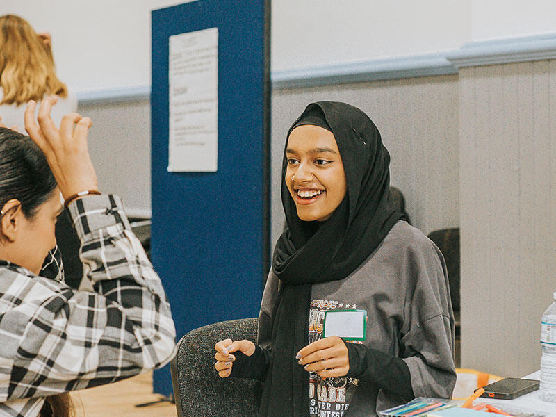 A girl smiles during a workshop