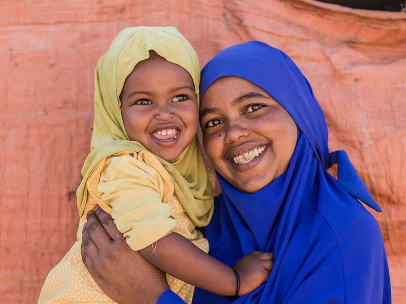 A woman and child smile at the camera