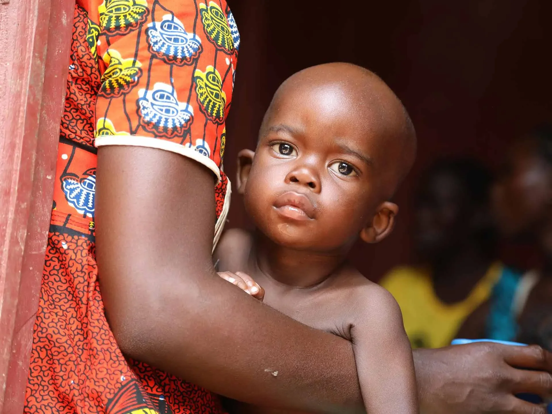 A small baby being held in his mother's arms