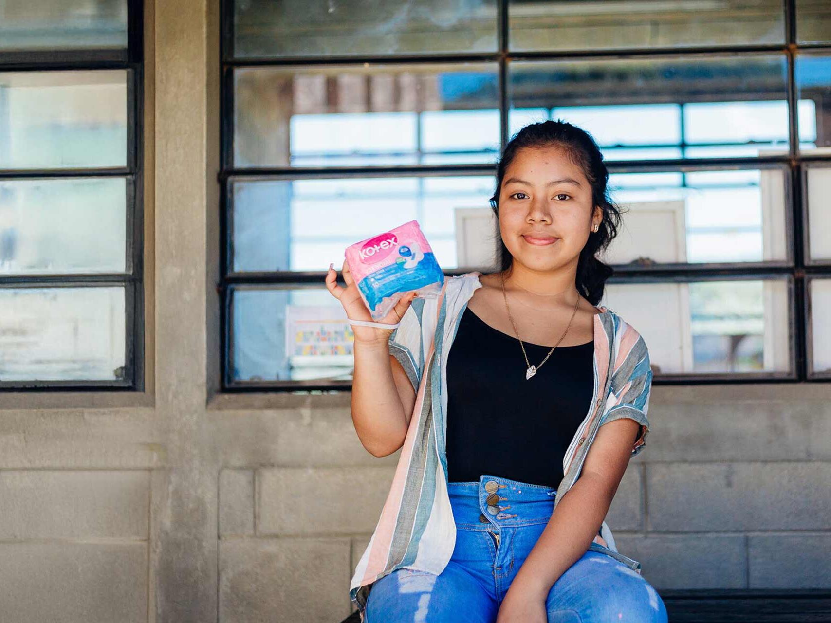 Dalila, 15, holding a dignity kit distributed by Plan International