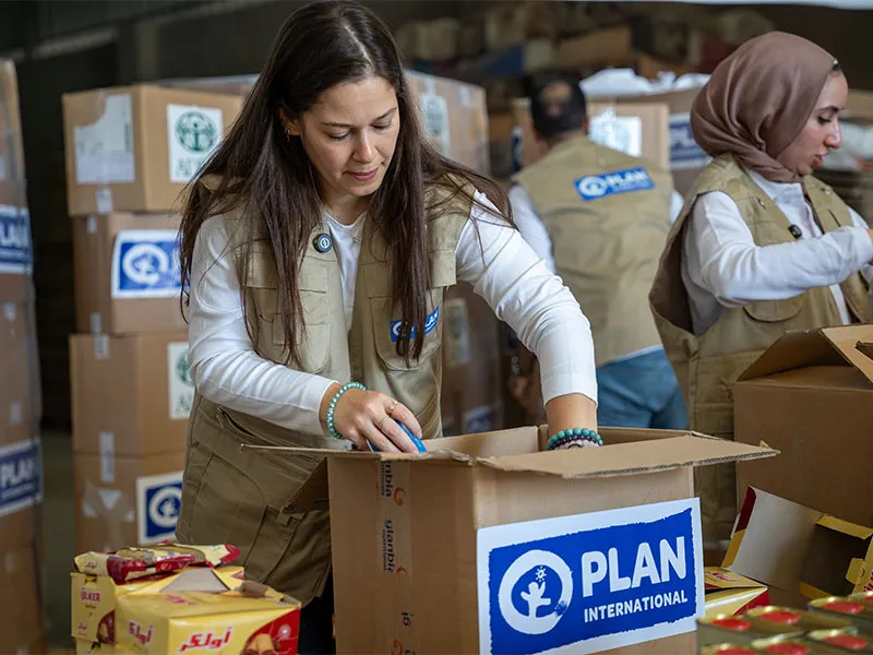 Aid worker packs food boxes for emergency response.