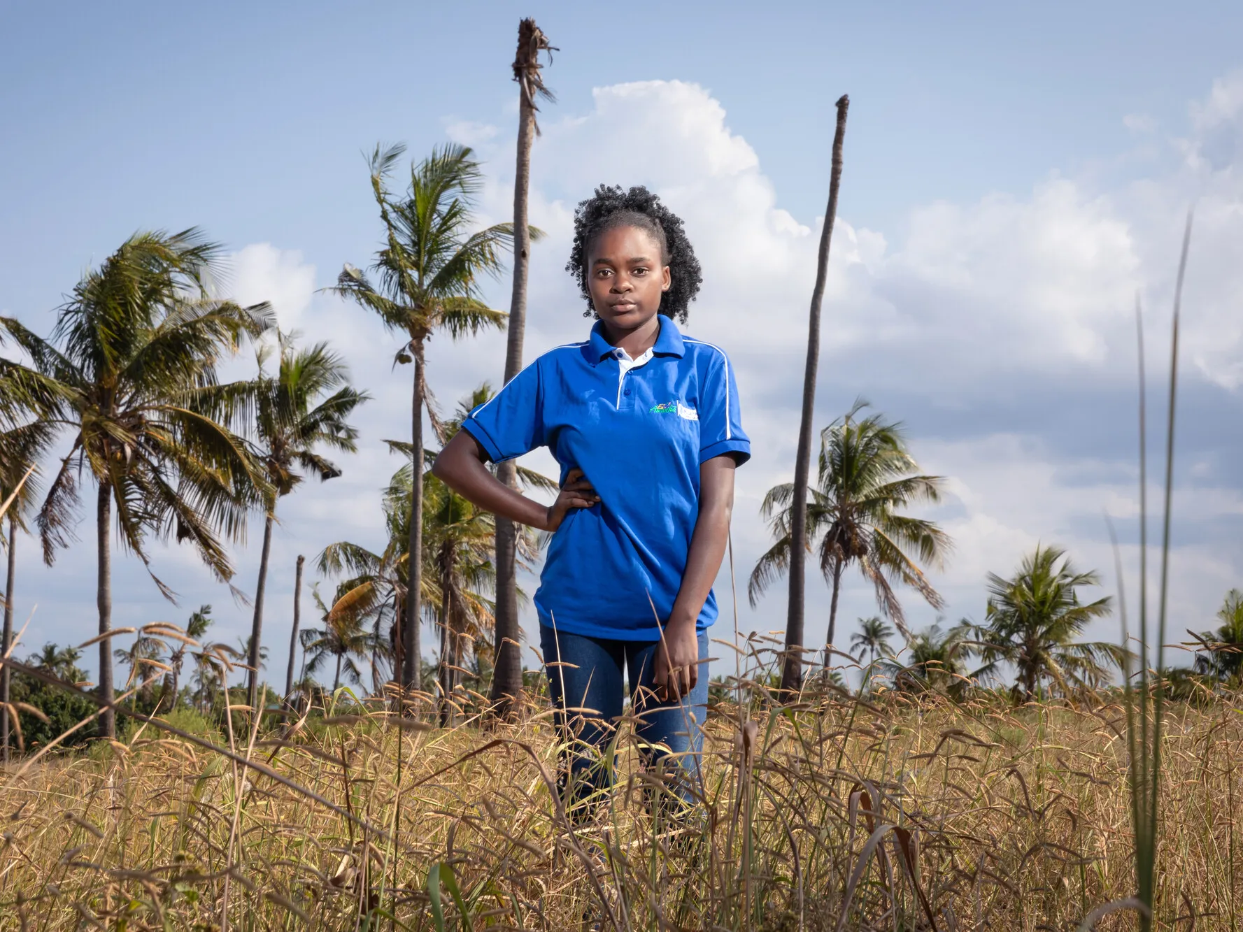 Eunice, 18, stands in a field in Mozambique. She is passionate about defending the rights of girls