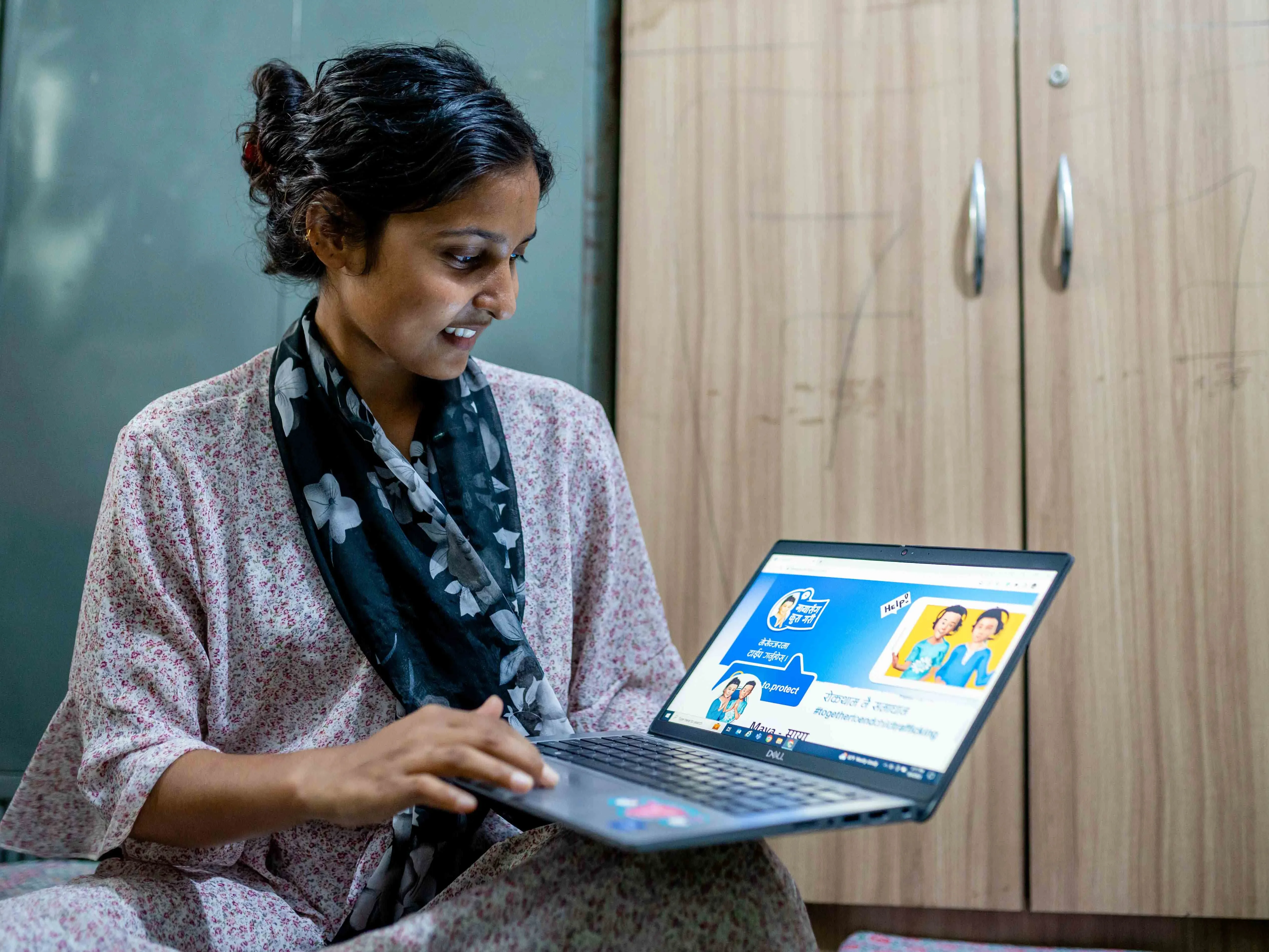 Rahimat, 18, looks at the Maya ChatBot website on her laptop in Nepal. 