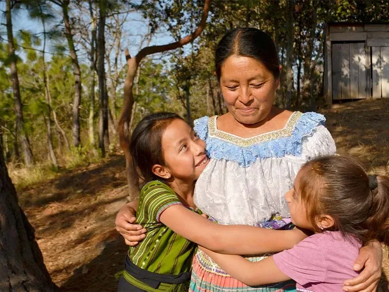 Jenifer hugging her mother and younger sister