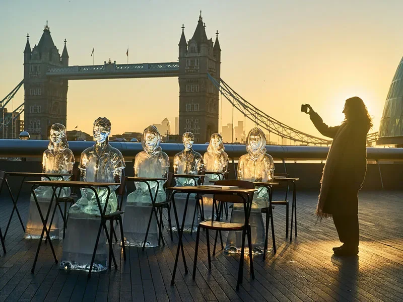 Ice sculptures of school girls are positioned next to the Thames. 