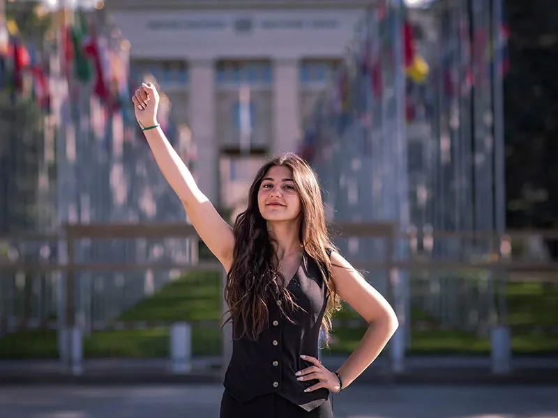 Lynne, 18, raising a clenched fist in solidarity whilst looking at the camera.