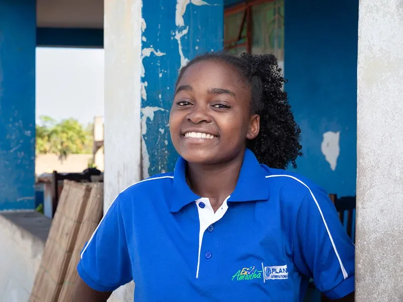 Eunice, 18, wears a blue shirt. She is smiling at the camera.