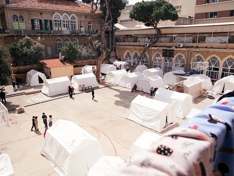 White tents are erected on the grounds of a school in Beirut.