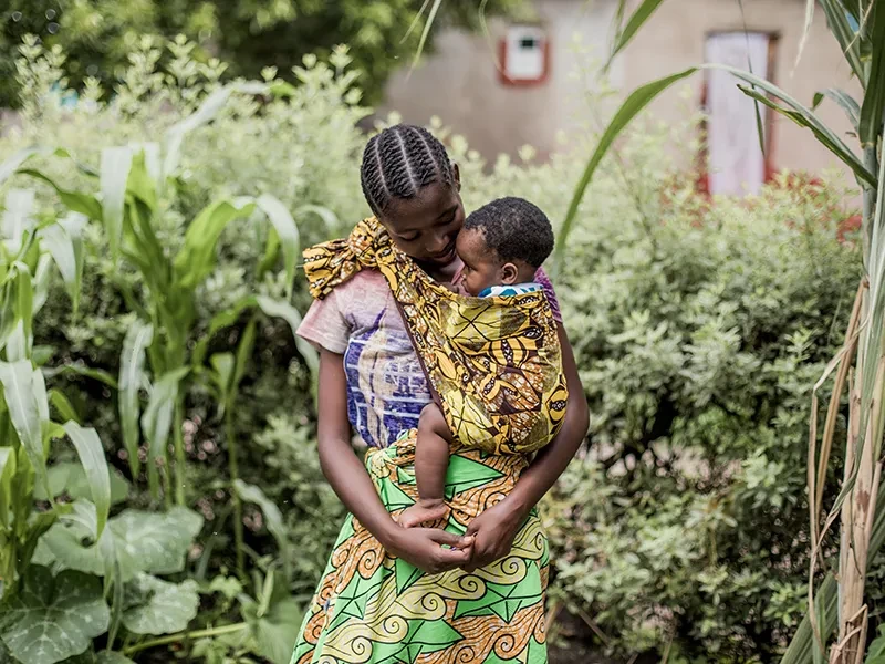 Melissa, 18, from Zambia, cradles her baby in her arms.