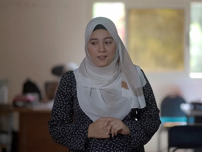 Maysa, 23, from Egypt, stands in a classroom and speaks to a group of students.