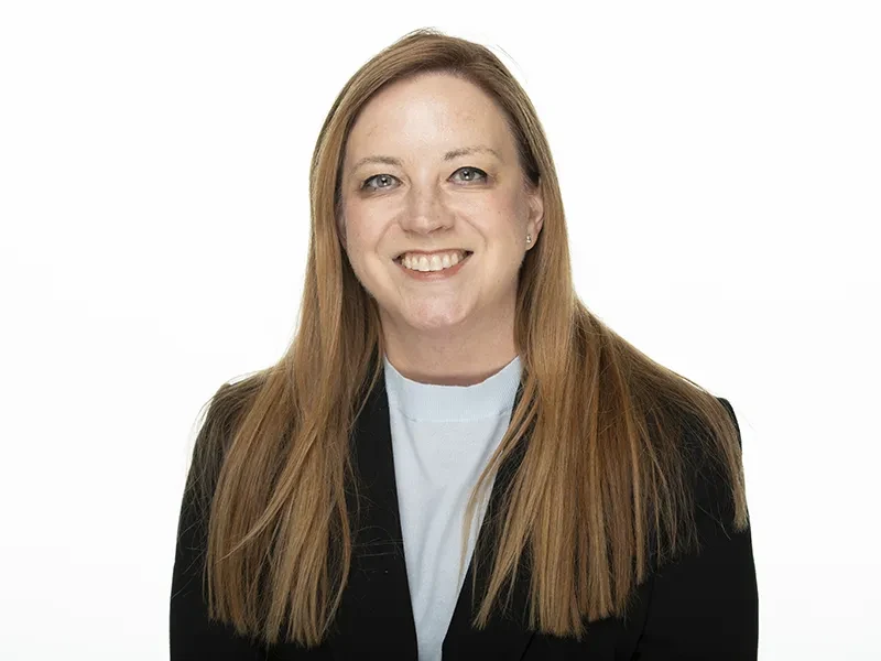 Meredith Niles looks at the camera. She is smiling and wearing a black blazer.