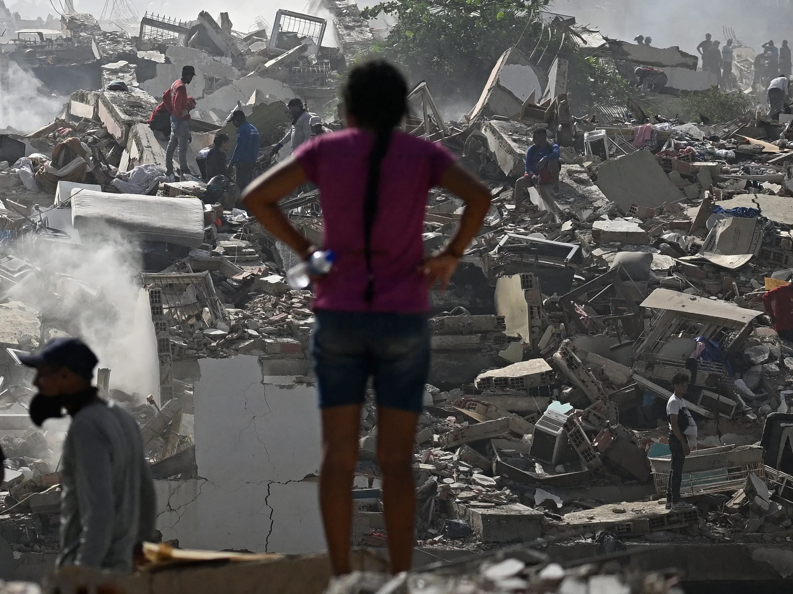 Volunteers search for survivors in a collapsed building following the twin earthquakes in La Guaira state, Venezuela